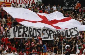 Locura en Gerona: Miles de independentistas salen a la calle a celebrar que jugarán en la liga española Pancarta de "perros españoles" en el campo del Gerona.